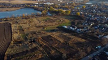 Beautiful rural country landscape houses, agricultural plowed fields, lakes ponds for growing fish, gardens, horticulture, home, village, city on sunny autumn day. Aerial drone view. Agrarian scenery