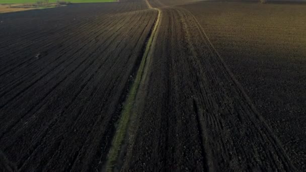 秋天里阳光灿烂的时候耕地的景观 用黑土在犁地上飞行 地面土的起爆 土地背景 黑土空中无人驾驶飞机视图 — 图库视频影像