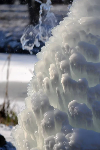 공원에 분출공이요 얼어붙은 찬물에 샘에서 흘러내리는 말이야 공원의 뜰에는 눈으로 — 스톡 사진
