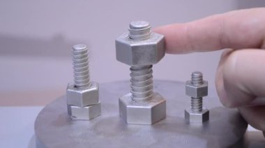 3 boyutlu yazıcıya lazer sinterle metal tozundan bir nesne basılmış. Metal yazıcıda yaratılan metal parçasında kadın parmağı büküyor. Seçici lazer eritme teknolojisi. Yeni modern teknolojiler