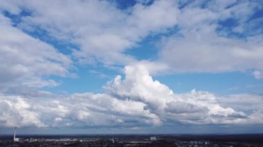 Gün boyunca güçlü rüzgar sırasında mavi gökyüzünde beyaz kümülüs bulutlarının hızlı hareketi. Panoramik doğal arka plan. Bulutlar. Manzara manzarası. Yağmurlu bulutlu hava. Hava aracı görünümü.