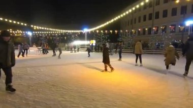 Kyiv, Ukrayna, 13 Ocak 2019 açık hava buz pateni pisti. Birçok insan yeni yıl ve yılbaşı ışıklarıyla süslenmiş açık hava buz pateni pistinde paten kayıyor.