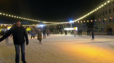 Kyiv, Ukrayna, 13 Ocak 2019 açık hava buz pateni pisti. Birçok insan yeni yıl ve yılbaşı ışıklarıyla süslenmiş açık hava buz pateni pistinde paten kayıyor.