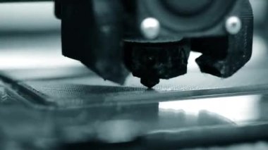 3D yazıcı. 3D yazıcı yakın plan yazdırıyor. Erimiş plastik Extruder 'dan akıyor ve prototip modelini oluşturuyor. 3D yazıcı için yeni modern katkı teknolojileri. Modelleme için elektronik aygıt.