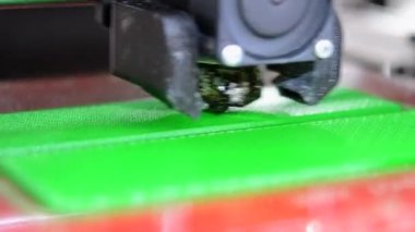 3D yazıcı. 3D yazıcı yakın plan yazdırıyor. Erimiş plastik Extruder 'dan akıyor ve prototip modelini oluşturuyor. 3D yazıcı için yeni modern katkı teknolojileri. Modelleme için elektronik aygıt.