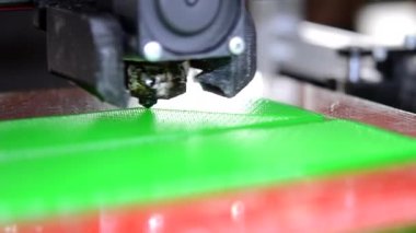 3D yazıcı. 3D yazıcı yakın plan yazdırıyor. Erimiş plastik Extruder 'dan akıyor ve prototip modelini oluşturuyor. 3D yazıcı için yeni modern katkı teknolojileri. Modelleme için elektronik aygıt.