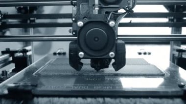 3D yazıcı. 3D yazıcı yakın plan yazdırıyor. Erimiş plastik Extruder 'dan akıyor ve prototip modelini oluşturuyor. 3D yazıcı için yeni modern katkı teknolojileri. Modelleme için elektronik aygıt.