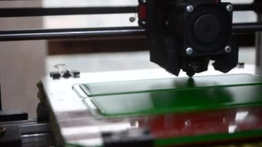 3D yazıcı. 3D yazıcı yakın plan yazdırıyor. Erimiş plastik Extruder 'dan akıyor ve prototip modelini oluşturuyor. 3D yazıcı için yeni modern katkı teknolojileri. Modelleme için elektronik aygıt.