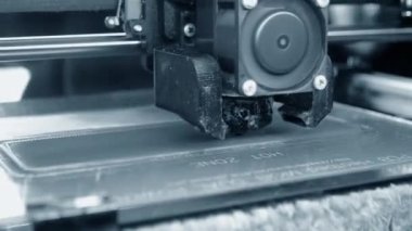 3D yazıcı. 3D yazıcı yakın plan yazdırıyor. Erimiş plastik Extruder 'dan akıyor ve prototip modelini oluşturuyor. 3D yazıcı için yeni modern katkı teknolojileri. Modelleme için elektronik aygıt.