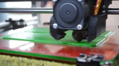 3D yazıcı. 3D yazıcı yakın plan yazdırıyor. Erimiş plastik Extruder 'dan akıyor ve prototip modelini oluşturuyor. 3D yazıcı için yeni modern katkı teknolojileri. Modelleme için elektronik aygıt.