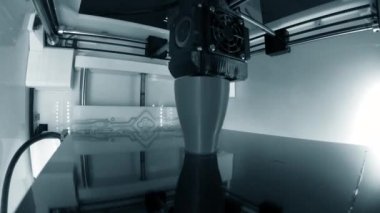 3D yazıcı. 3D yazıcı yakın plan yazdırıyor. Erimiş plastik Extruder 'dan akıyor ve prototip modelini oluşturuyor. 3D yazıcı için yeni modern katkı teknolojileri. Modelleme için elektronik aygıt.