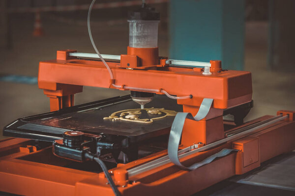 3d printer that printing a liquid dough. 3D printer printing pancakes with liquid dough different shapes close-up. Modern additive technologies 4.0 industrial revolution