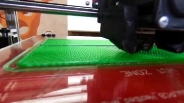 3D yazıcı. 3D yazıcı yakın plan yazdırıyor. Erimiş plastik Extruder 'dan akıyor ve prototip modelini oluşturuyor. 3D yazıcı için yeni modern katkı teknolojileri. Modelleme için elektronik aygıt.