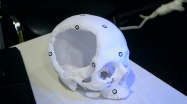 3D tarayıcılı bir adam, beyaz plastikten 3D yazıcıya basılmış insan kafatası prototipini tarıyor. Lazer tarama nesnesi. Nesne yakalamak için 3D tarayıcı. Yüksek yeni modern teknoloji ekipmanlarını kabul et