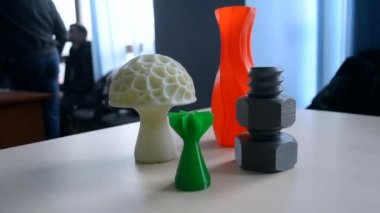 Masadaki üç boyutlu yazıcıya basılmış çok renkli plastik nesneler. Modeller 3D yazıcı basmış. Teknoloji FDM. Yeni modern katkı teknolojileri. 3D yazıcıda prototip oluşturma kavramı