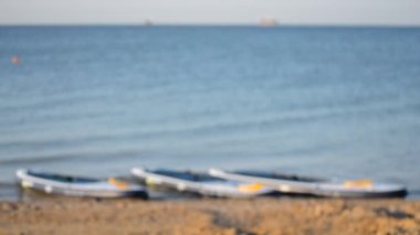 Güneşli bir yaz gününde kumlu sahil kıyısı yakınlarında deniz dalgalarının su yüzeyinde yiyecek tahtaları. Hiç kimse. Tatil tatili eğlence tatili turizmi kavramı. Bulanık arkaplan