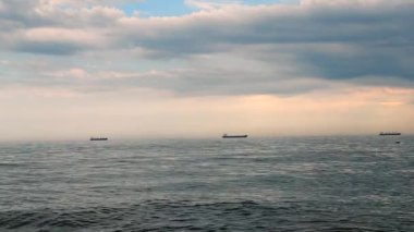 Dramatik deniz manzarası, deniz manzarası. Deniz, gökyüzünde büyük kara yağmur bulutları, tahıl tankeri gemileri, tahıl taşıyıcısı. Denizde yağmurlu hava, bulutlu. Yağmurlu atmosferik yağış kasırgası. Ulaşım