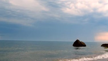 Güzel deniz manzarası, deniz manzarası. Deniz, şeffaf su, deniz dalgaları, deniz sahili, taşlar ve martılar, bulutlar, mavi gökyüzü, yaz günü yağmur. Tatil turizmi seyahat havası. Doğa doğal arkaplan