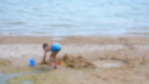 Fond Flou Petit Garçon Seul Jouant Dans Sable Sur Plage — Video