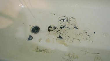Boya soyan eski paslı küvet. Banyodaki drenaj deliği ve musluktan akan su. Banyo deliği ve akan su. Eski püskü küvette akan su musluktan akan su.