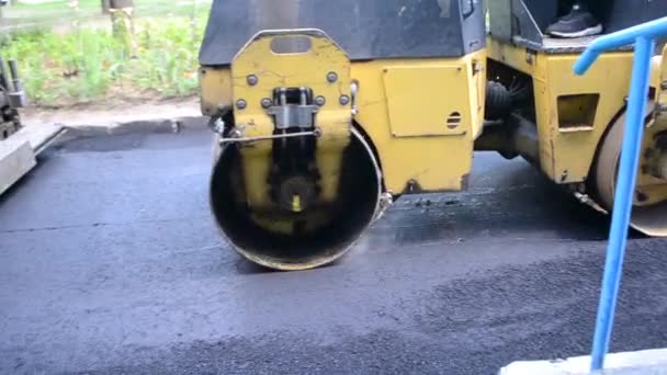 铺路机铺路机黄色的旧沥青机在街上滚烫的黑色沥青路面 — 图库视频影像