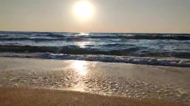 Denizde şafak vakti. Denizde gün batımı. Gündoğumu, okyanusta gün batımı. Ufukta parlayan güneş, mavi dalgalar. Güneş ışığı. Deniz manzarası manzarası. Deniz kıyısında. Doğal zemin, doğa zemin