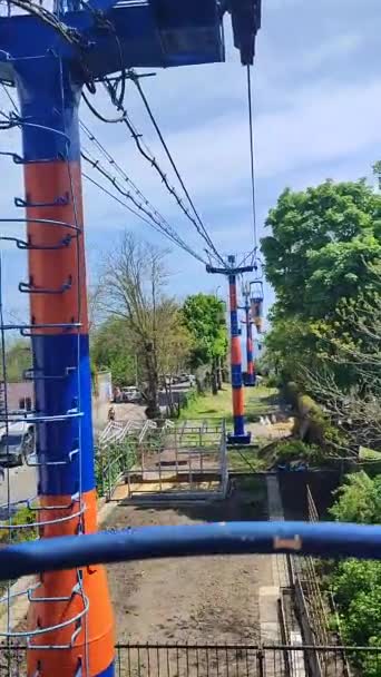晴れた春の夏の晴れた日に都市のさまざまなパターンで塗装多色のキャビンを持つケーブルカー 木々の間の観光ケーブルカー ロープウェイロープウェイ — ストック動画