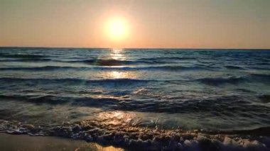 Denizde şafak vakti. Denizde gün batımı. Gündoğumu, okyanusta gün batımı. Ufukta parlayan güneş, mavi dalgalar. Güneş ışığı. Deniz manzarası manzarası. Deniz kıyısında. Doğal zemin, doğa zemin