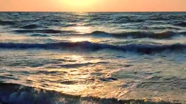 Denizde şafak vakti. Denizde gün batımı. Gündoğumu, okyanusta gün batımı. Beyaz köpük, mavi dalgalar. Güneş ışığı. Deniz manzarası manzarası. Deniz kıyısında. Doğal zemin, doğa zemin
