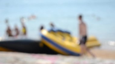 Bulanık arka plan deniz kumsalı. Birçok insan güneşli bir yaz gününde şişme tekne turu yapar. Tatil tatili dinlenme turizm dinlenme dinlenme tatil tatil dinlenme