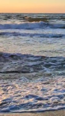 Denizde şafak vakti. Denizde gün batımı. Gündoğumu, okyanusta gün batımı. Beyaz köpük, mavi dalgalar. Güneş ışığı. Deniz manzarası manzarası. Deniz kıyısında. Doğal zemin, doğal zemin. Dikey