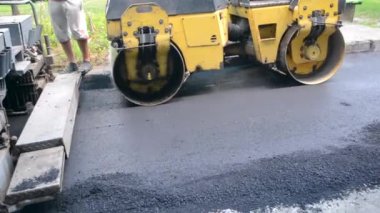 Bila Tserkva Ukrayna, 3 Haziran 2020: Paver, kaldırım makinesi. Sarı asfalt asfalt asfalt makinesi. Sokakta sıcak siyah asfalt yuvarlıyor..