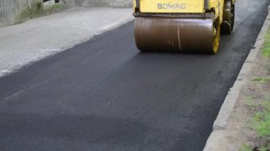 Bila Tserkva Ukrayna, 3 Haziran 2020: Paver, kaldırım makinesi. Sarı asfalt asfalt asfalt makinesi. Sokakta sıcak siyah asfalt yuvarlıyor..