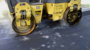 Bila Tserkva Ukrayna, 3 Haziran 2020: Paver, kaldırım makinesi. Sarı asfalt asfalt asfalt makinesi. Sokakta sıcak siyah asfalt yuvarlıyor..