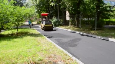 Bila Tserkva Ukrayna, 3 Haziran 2020: Paver, kaldırım makinesi. Sarı asfalt asfalt asfalt makinesi. Sokakta sıcak siyah asfalt yuvarlıyor..