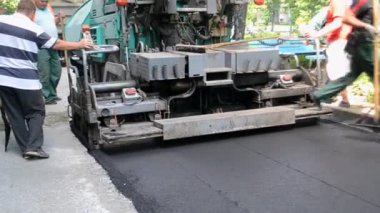 Bila Tserkva Ukrayna, 3 Haziran 2020: Büyük asfalt kaldırım makinesi ve insanlar. Paver, kaldırım makinesi. Büyük, eski asfalt asfalt asfalt makinesi. Sokakta sıcak, siyah asfalt yuvarlıyor..