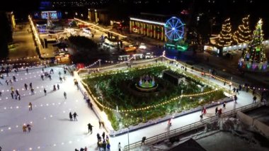 Kyiv, Ukrayna 20 Ocak 2022: İnsanlar açık havada güzel buz pateni pistlerinde kayıyorlar. Yeni yıl süsleri, dekorasyonlar, kış gecelerinde parlak çelenkler. Yeni yıl Noel 'i