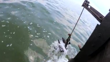 Eski paslı çapa ipte sallanıyor ve denizin yüzeyinde yüzen ahşap bir geminin kıç tarafında sendeliyor. Gemide yelken açmak, gemide yüzmek. Seyahat tatili