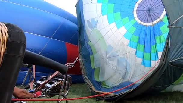 大气球躺在地上 从燃烧的气体的火焰中注入热空气 气球充满了热空气 燃气燃烧器的火焰使热气球膨胀 热气球 休闲娱乐旅游 — 图库视频影像