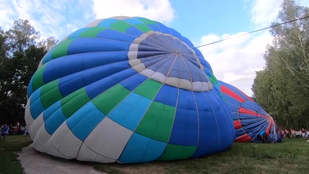 風船を地面に寝そべって膨らませる バルーンフェスティバルでは大きな青い風船が空気で膨らまされます 気球充填空気 バルーニングだ レジャーエンターテイメント観光レクリエーション残りの旅行活動 — ストック動画
