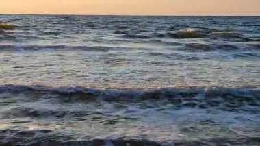 Denizde şafak vakti. Denizde gün batımı. Gündoğumu, okyanusta gün batımı. Beyaz köpük, mavi dalgalar. Güneş ışığı. Deniz manzarası manzarası. Deniz kıyısında. Doğal zemin, doğa zemin