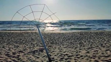 İskelet tasarımı plaj şemsiyesi güneşli bir yaz gününde deniz kıyısının kumlu sahilinde eğildi. Terk edilmiş plaj. Hiç kimse. Deniz manzarası manzarası. Deniz kıyısı arkaplanı