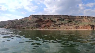 Sahilden sahile, denizden denize, gemiden gemiye. Güneşli bir yaz günü. Kıyıdaki Dağ Tepesi. Gemide yüzen yelken. Tekneyle açılmak. Deniz manzaralı deniz manzarası. Manzara manzarası. Yavaş çekim