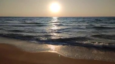 Denizde şafak vakti. Denizde gün batımı. Güneş ışığı. Gündoğumu, okyanusta gün batımı. Ufukta parlayan güneş, mavi dalgalar. Deniz manzarası manzarası. Deniz kıyısında. Doğa zemin, doğal zemin