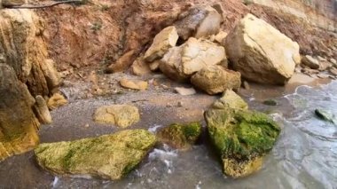 Büyük sarı kum kil taşları deniz kıyısındaki kumlu sahilde kayalar. Deniz kıyısı sahil kıyısı sahil şeridi kıyı şeridi. Doğal manzara arka planı. Doğa manzarası