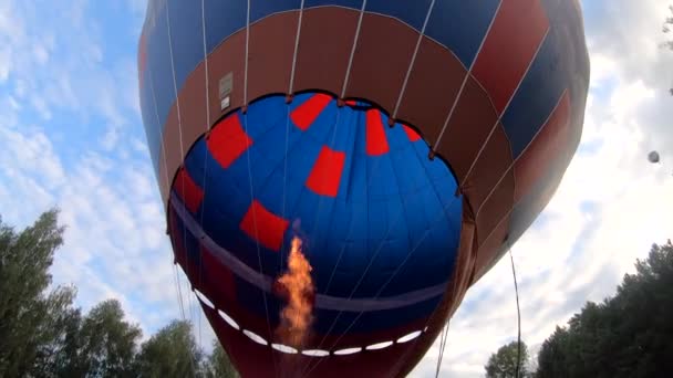燃焼ガス炎から大きな青い赤い気球の熱風を充填します エアロスタットが爆発し炎の燃焼ガスから熱風が発生 炎の燃える火 バルーニングだ エンターテイメント観光レクリエーションスローモーション — ストック動画