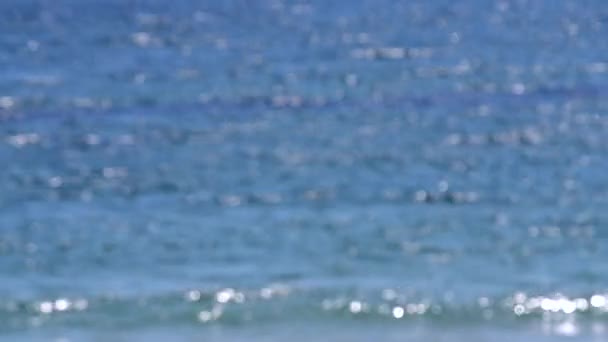 晴れた夏の日に水面の波紋から波と白いボケスポットと青い海の抽象的なビュー 海の海の川の湖の水を移動 自然な背景 自然を背景に ぼやけた背景 — ストック動画