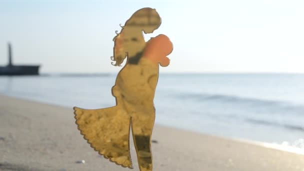 在阳光明媚的夏日里 相亲相爱的女孩和男人抱在沙滩上的塑料塑像棒 概念符号爱的喜悦坠入爱河的情人心爱的人 — 图库视频影像