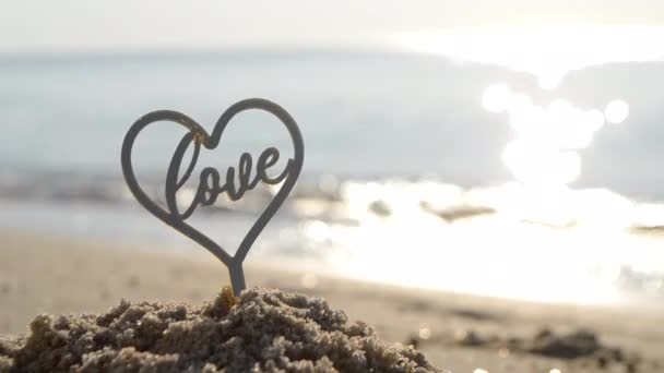 Plastikstäbchen Herzform Und Das Wort Liebe Sand Strand Einem Sonnigen — Stockvideo