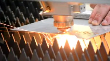 Metal lazer kesimi. Lazer metalin yakın plan kesimiyle metal levha kesimi. Fabrikada metal kesmek için endüstriyel ekipman makinesi. Kıvılcımlar saçar. Metal işleri üretim arka planı